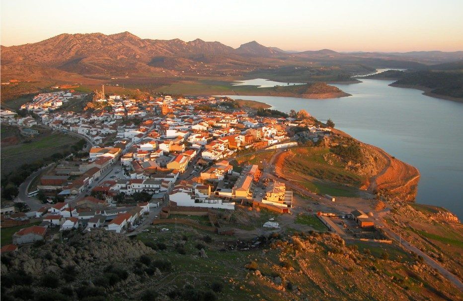 Vista aérea de Alange junto al embalse al atardecer, con la sierra al fondo