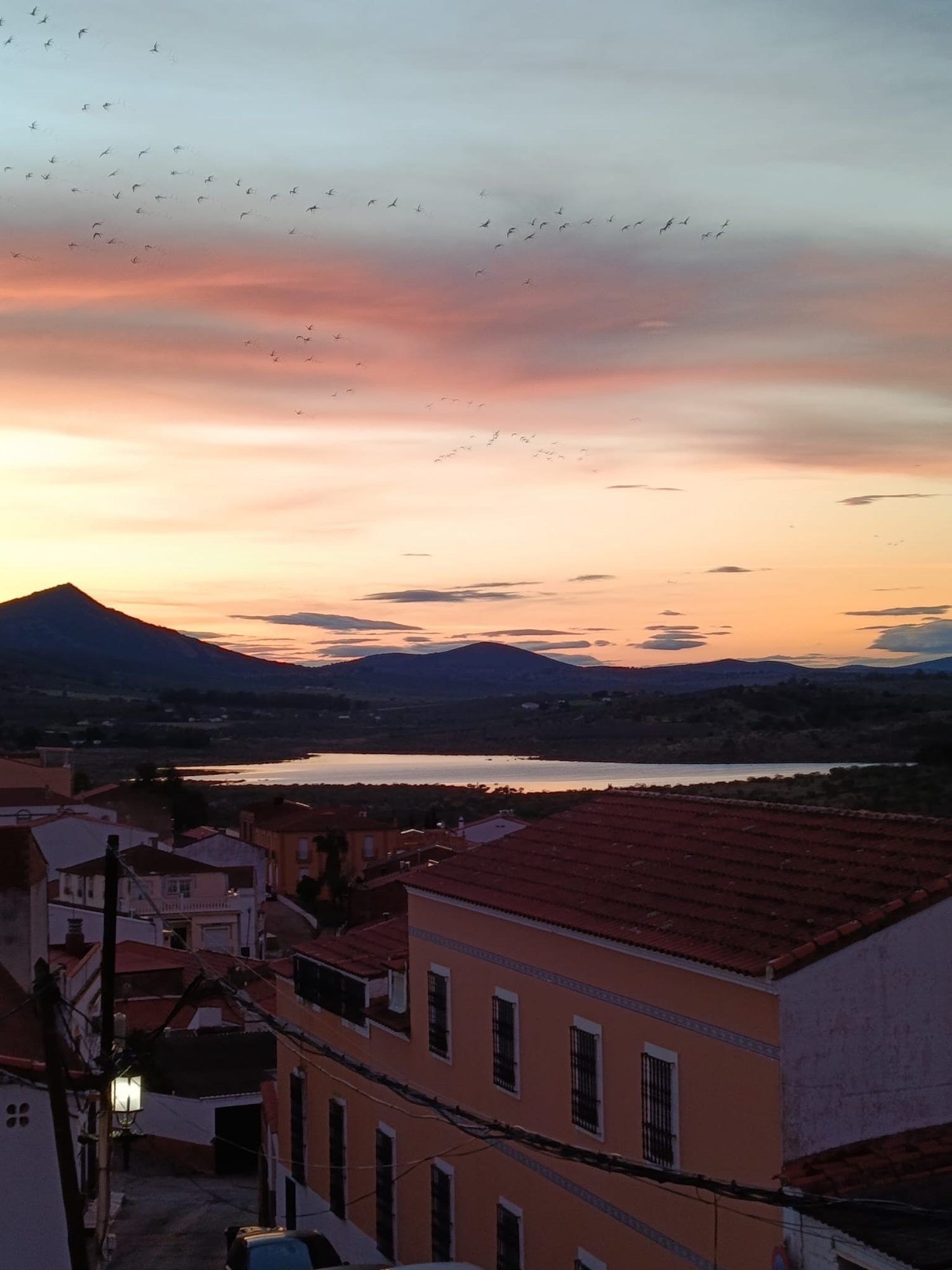 El amanecer sobre los tejados de Alange y el embalse
