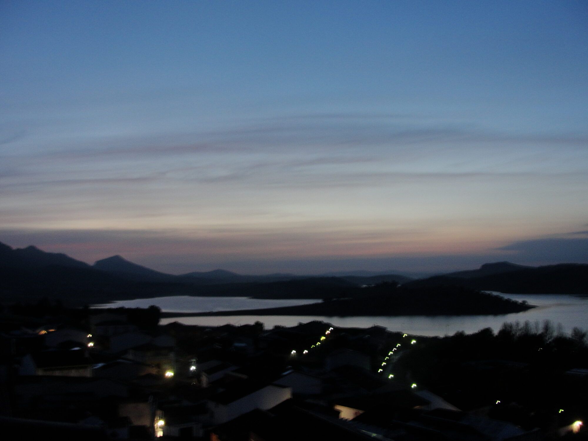 Las luces del pueblo al anochecer, con el embalse al fondo
