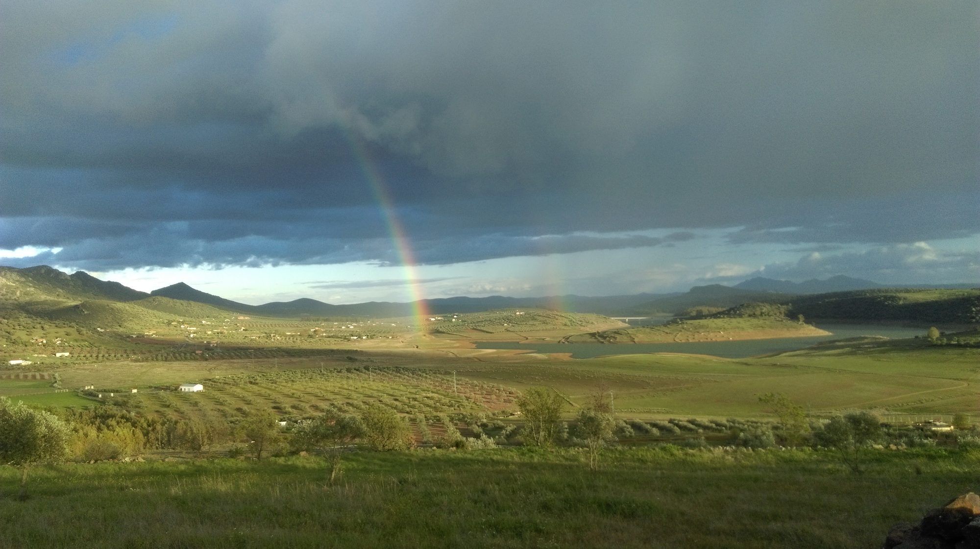 Arcoíris sobre el campo y el embalse