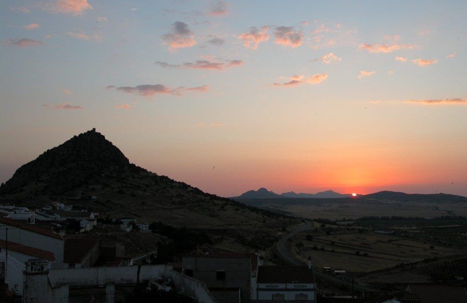 Atardecer detrás del cerro, sobre los tejados del pueblo