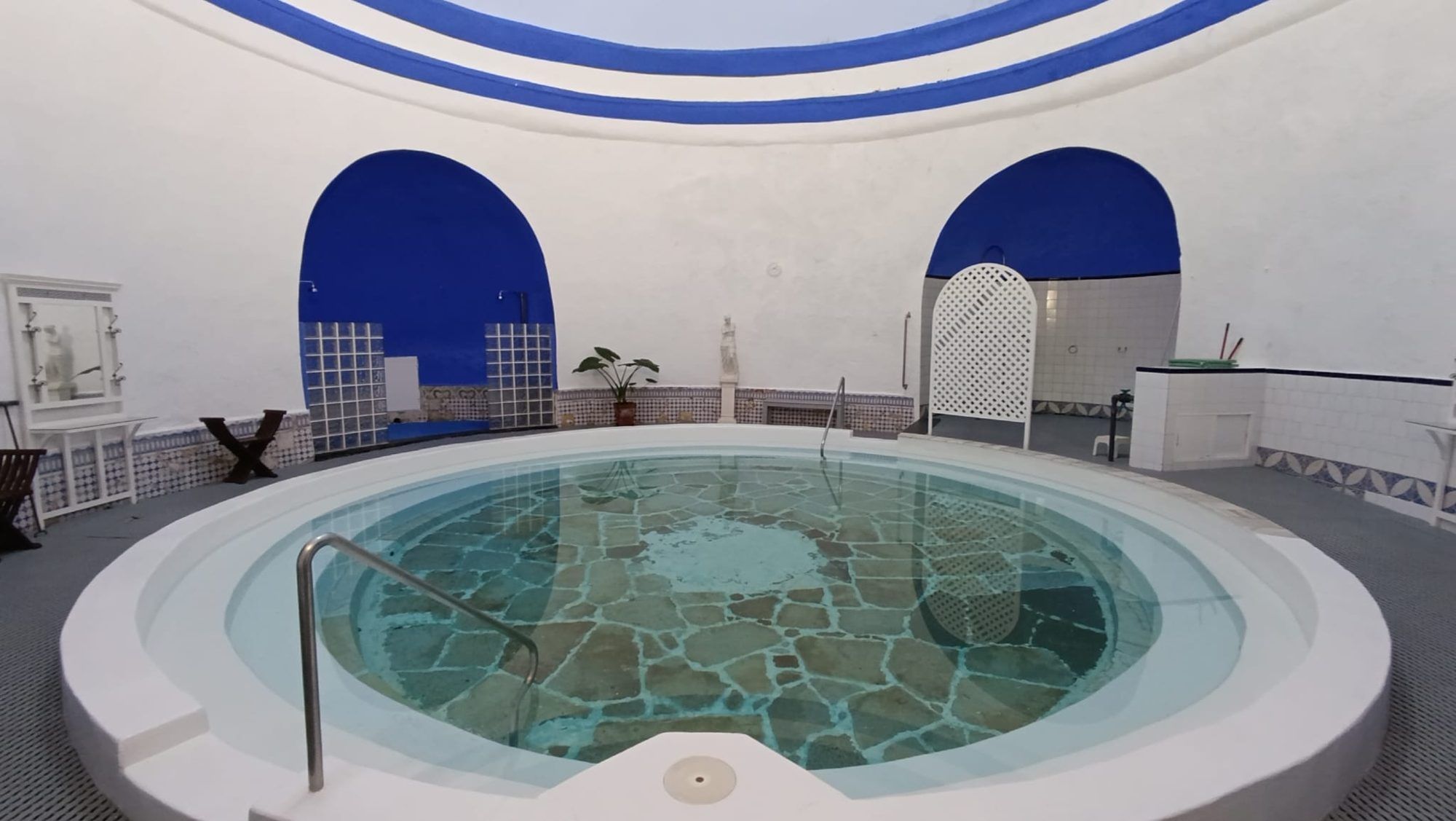 Piscina termal circular del balneario, con arcos azules