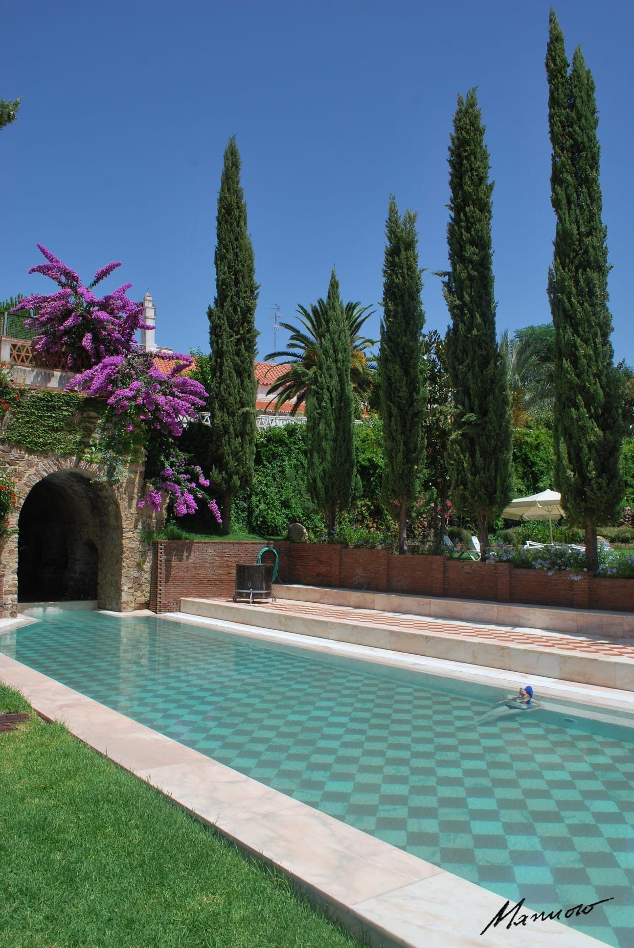 La piscina exterior del balneario de Alange, entre cipreses y buganvilla