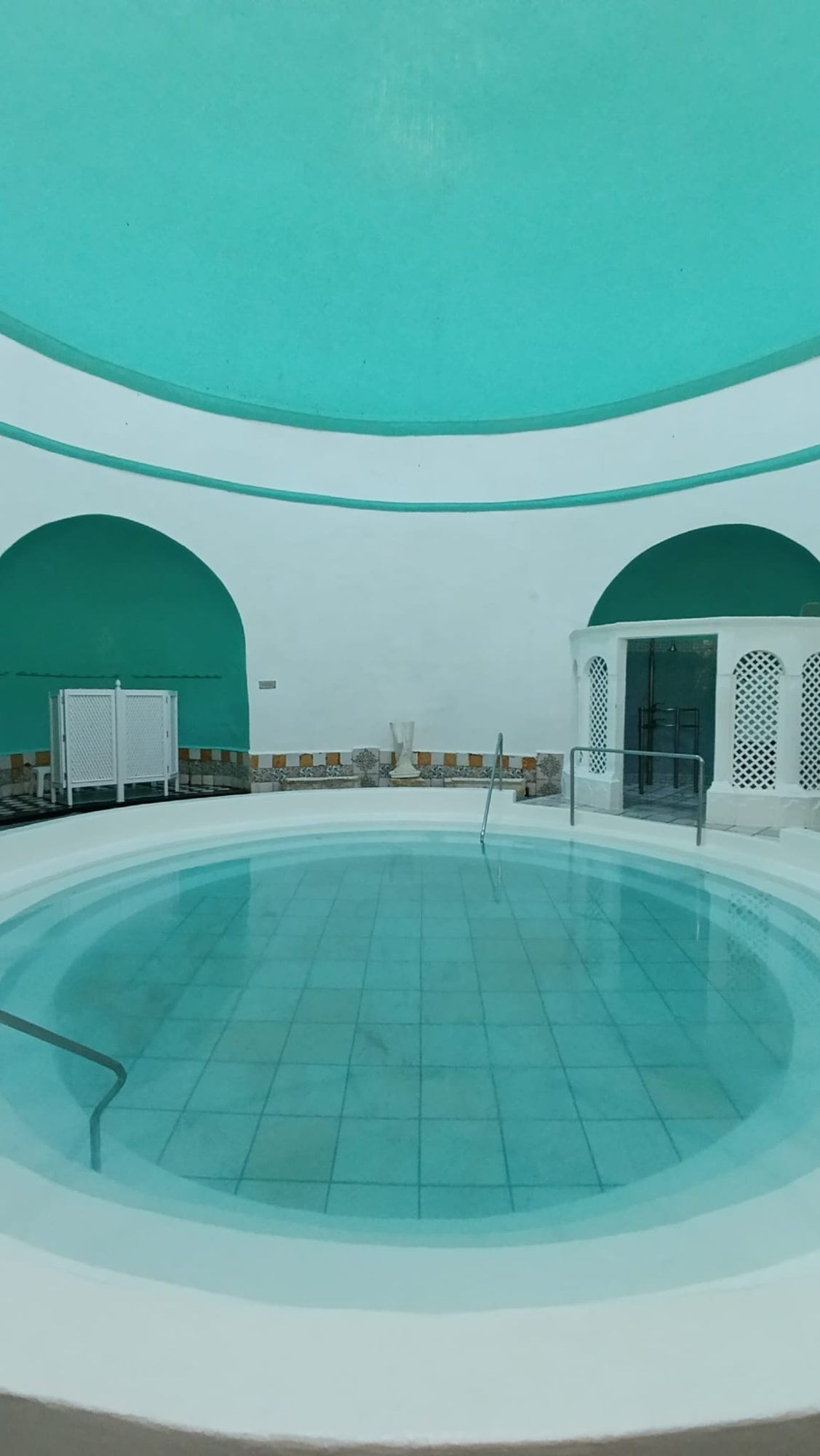Piscina termal del balneario con la cúpula en tonos turquesa