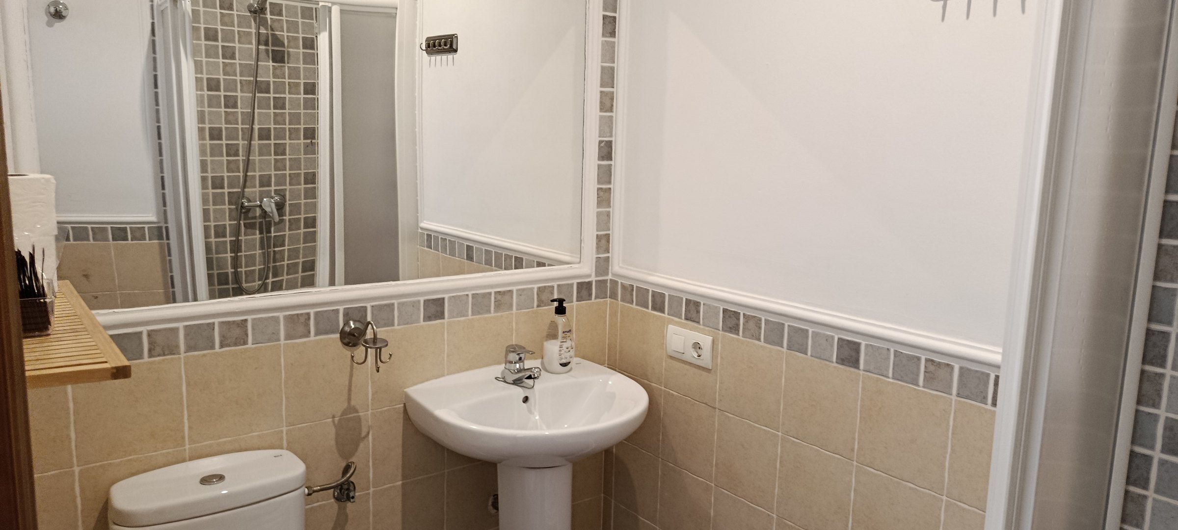 Baño en suite de una de las habitaciones, con la ducha, el lavabo y las toallas