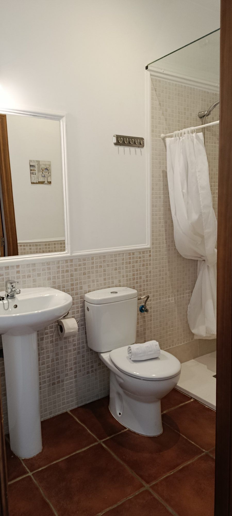 Baño de la habitación Jara, con lavabo de pie, inodoro y ducha con cortina