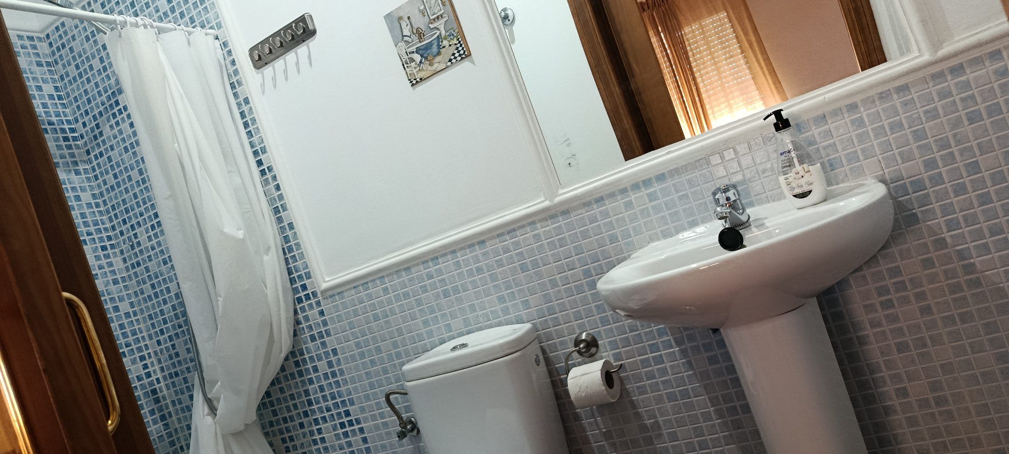 Lavabo y espejo del baño de la habitación Malva, con azulejo azul