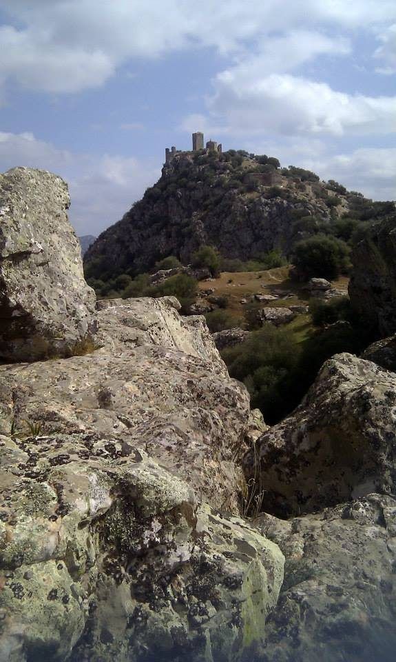 Castillo en lo alto del cerro, visto entre las rocas