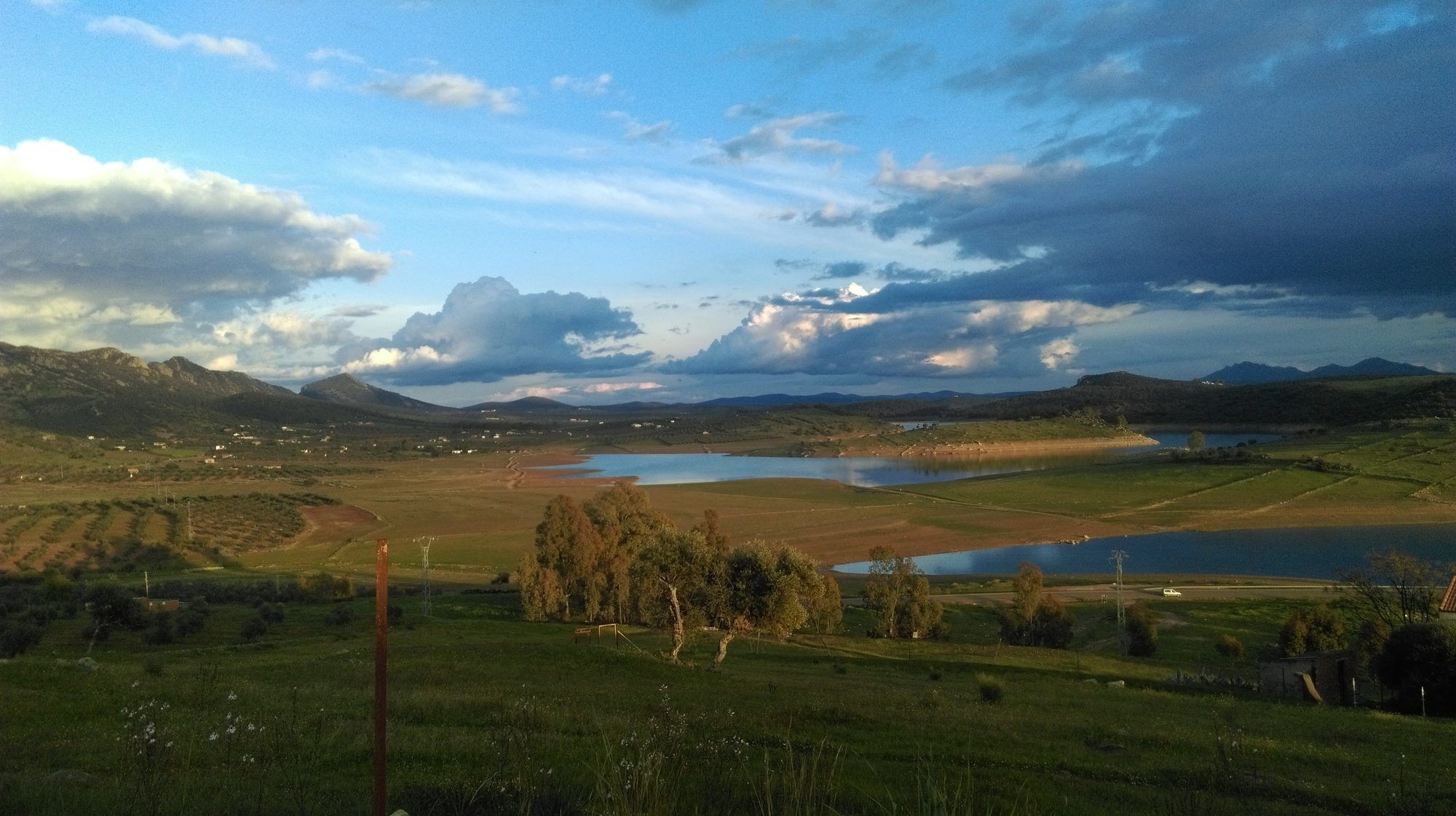 Luz entre las nubes sobre el embalse y la sierra