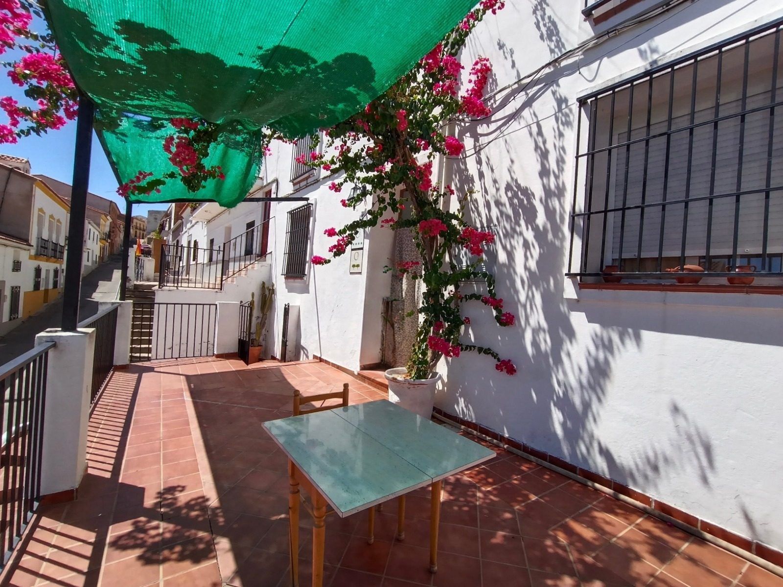 Mesa de la terraza de entrada bajo la buganvilla
