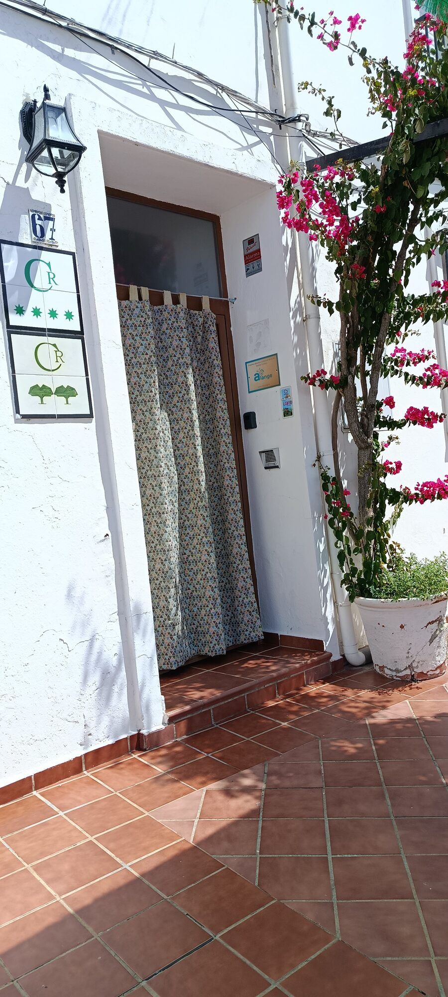 La entrada de la casa bajo la buganvilla en flor