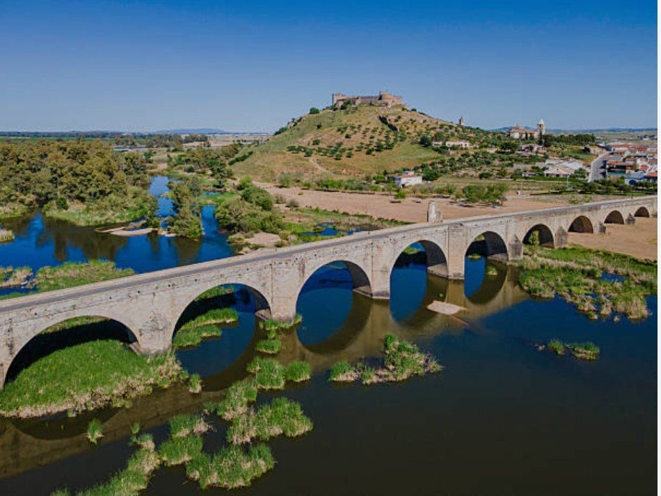 El puente sobre el Guadiana y, al fondo, el castillo de Medellín en lo alto del cerro