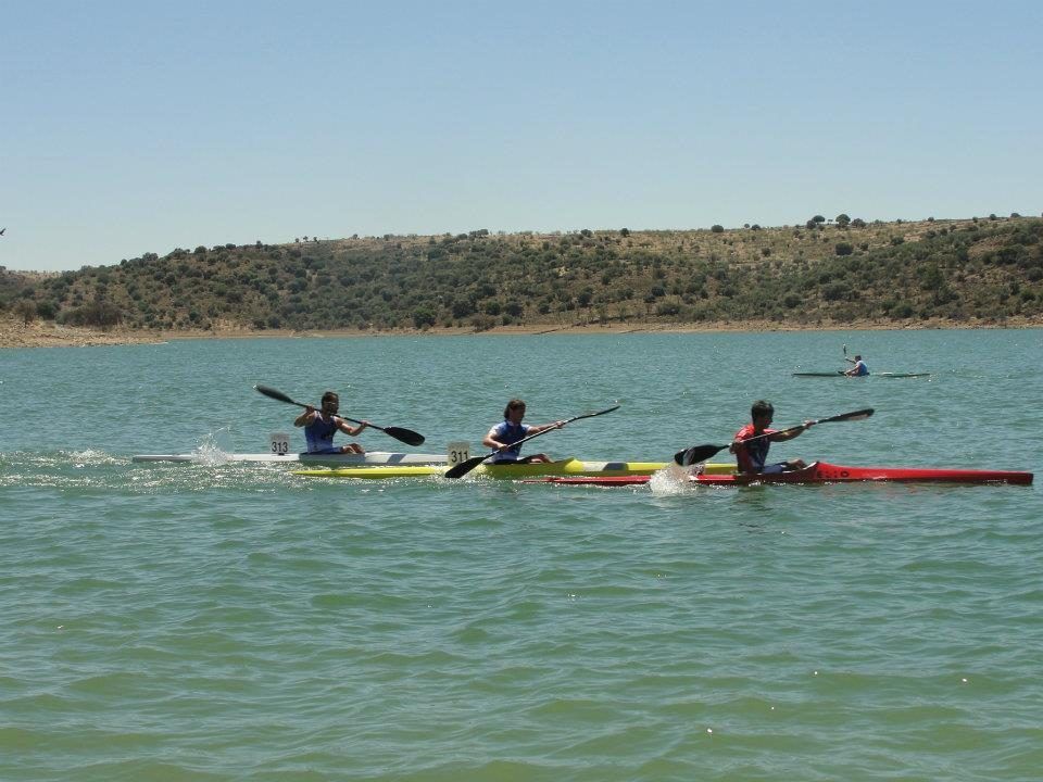 Tres piragüistas remando en el embalse de Alange