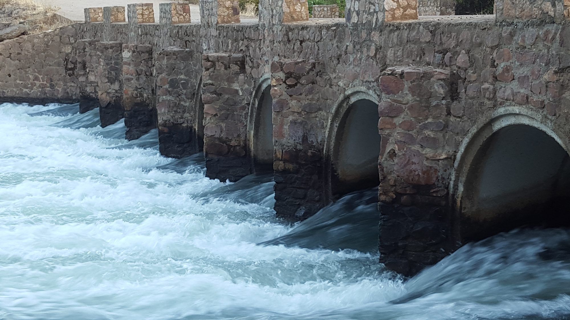 Agua bajo los arcos del puente del río Matachel