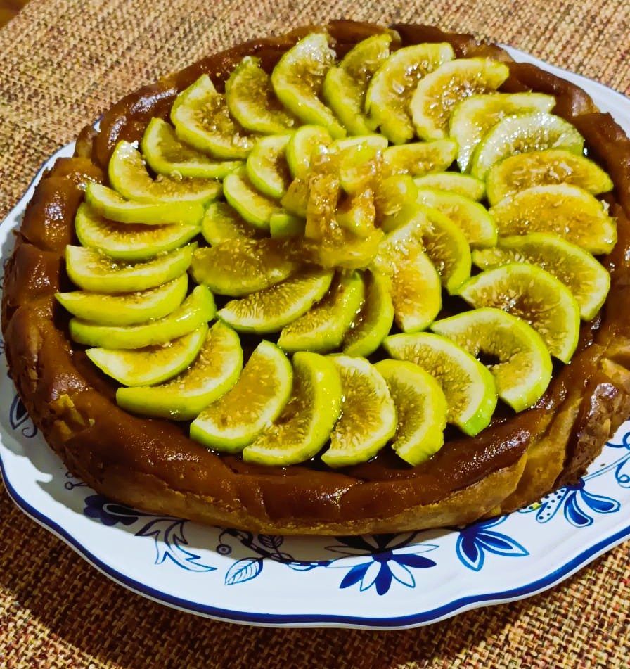 Tarta casera cubierta de higos frescos en abanico, sobre un plato de loza azul