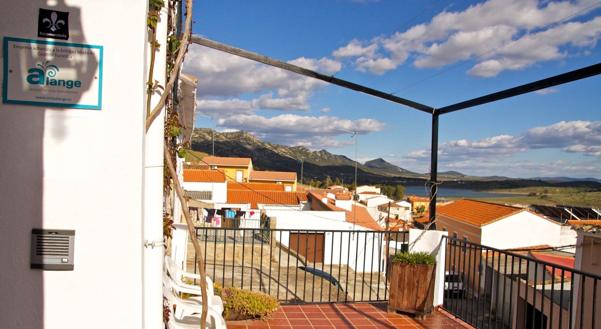 La entrada de la casa y su terraza, con el embalse al fondo